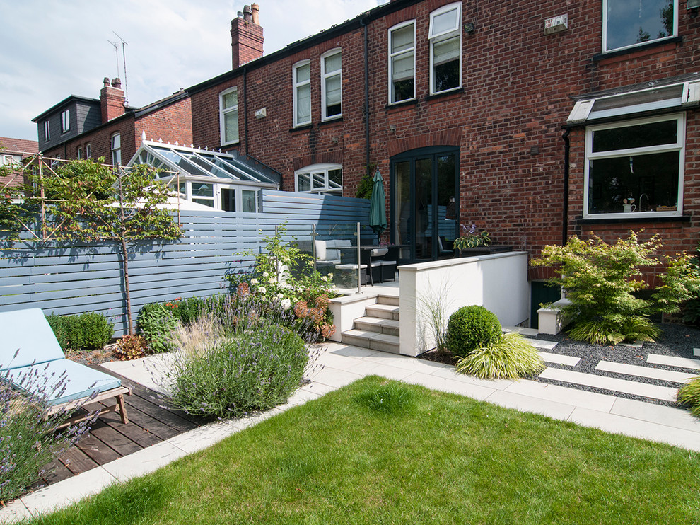 Immagine di un piccolo giardino formale classico esposto in pieno sole dietro casa in estate con un ingresso o sentiero e pavimentazioni in pietra naturale