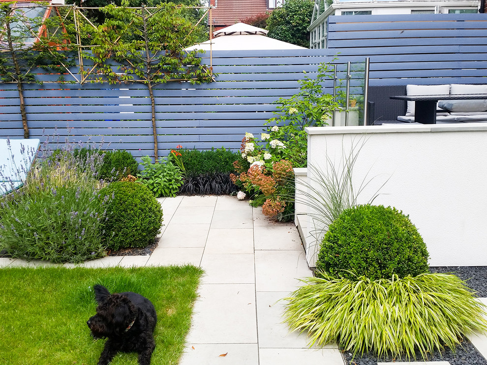 Geometrische, Kleine Klassische Gartenmauer im Sommer, hinter dem Haus mit direkter Sonneneinstrahlung und Natursteinplatten in Manchester