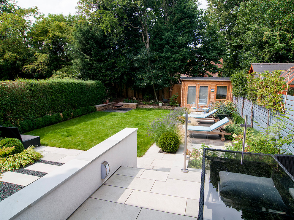 Photo of a small classic back formal full sun garden for summer in Manchester with a retaining wall and natural stone paving.