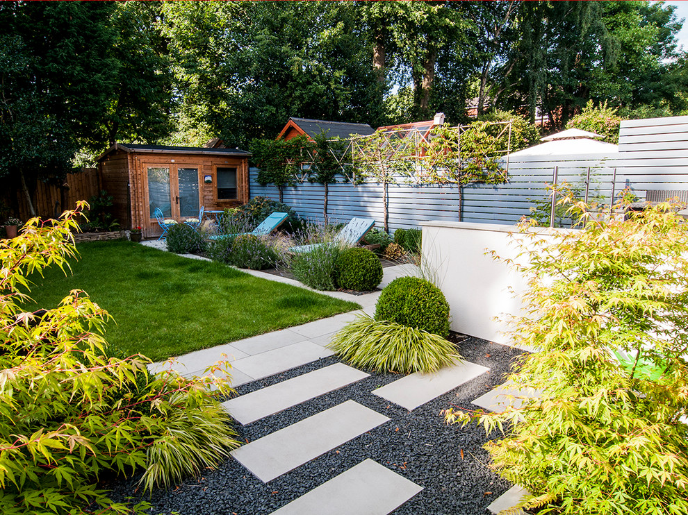 Medium sized contemporary back full sun garden for summer in Manchester with natural stone paving and a garden path.