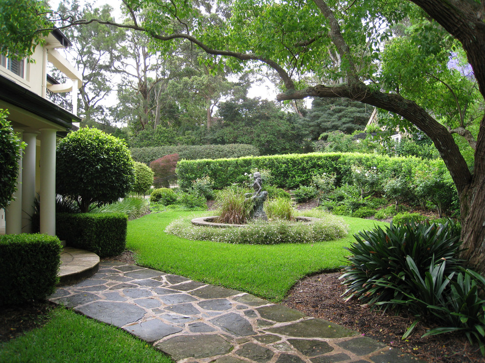 Diseño de jardín tradicional en patio delantero con fuente