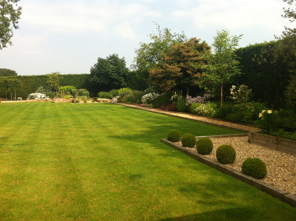Geometrischer, Geräumiger Moderner Kiesgarten im Sommer, hinter dem Haus mit direkter Sonneneinstrahlung und Rasenkanten in Cheshire