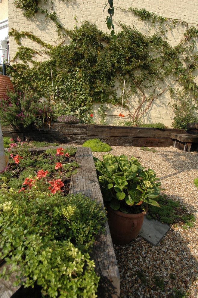 На фото: солнечный участок и сад среднего размера на заднем дворе в средиземноморском стиле с хорошей освещенностью и покрытием из гравия