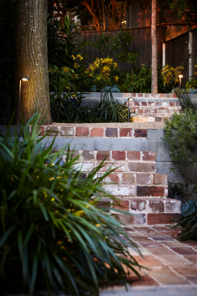 На фото: весенний засухоустойчивый сад на заднем дворе в современном стиле с мощением клинкерной брусчаткой