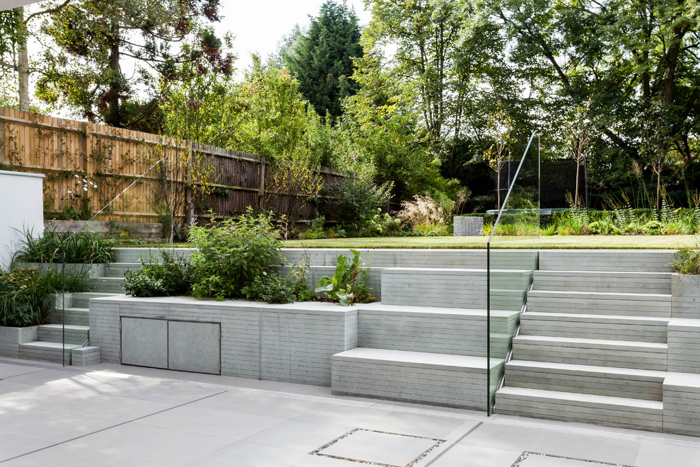Immagine di un grande giardino formale contemporaneo esposto in pieno sole dietro casa con pavimentazioni in pietra naturale