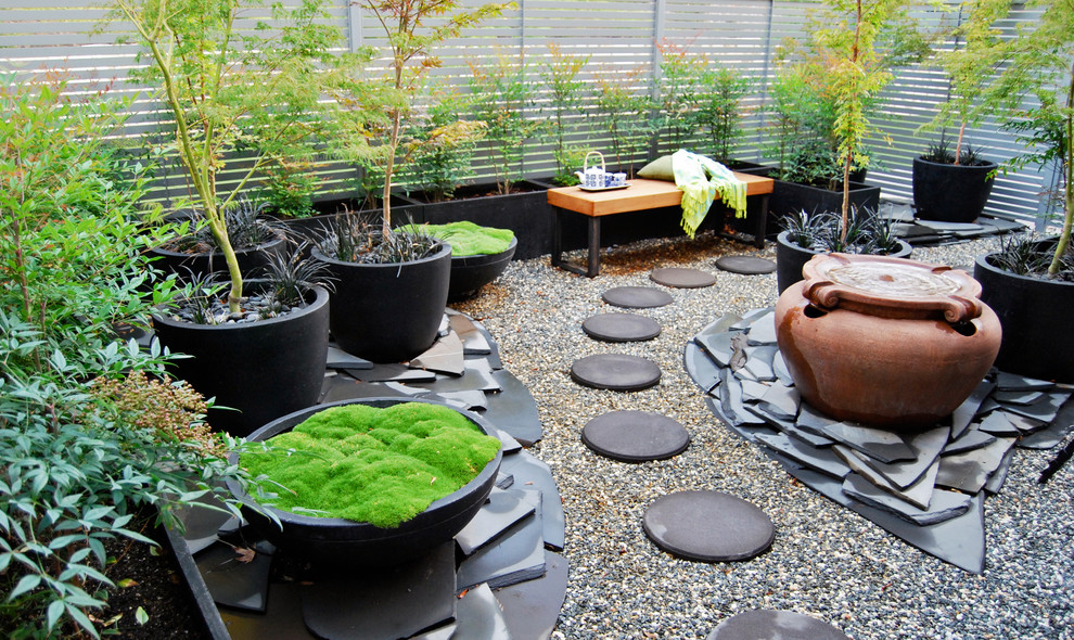 Стильный дизайн: маленький тенистый регулярный сад на внутреннем дворе в восточном стиле с растениями в контейнерах и покрытием из гравия для на участке и в саду - последний тренд