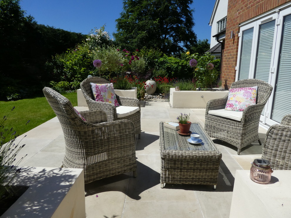 Medium sized contemporary back patio in Cheshire with natural stone paving.