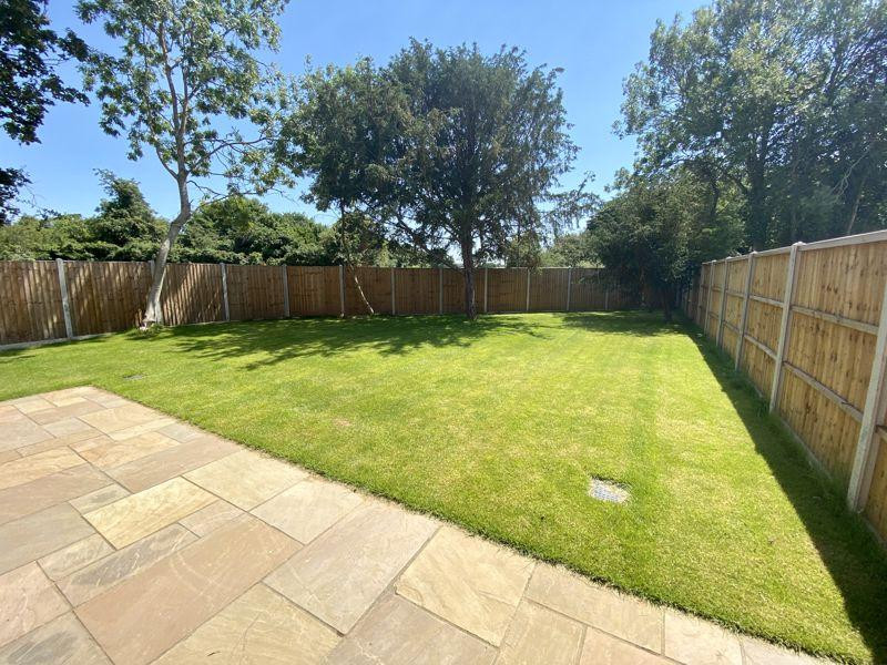 Immagine di un ampio giardino formale minimalista esposto in pieno sole dietro casa con pavimentazioni in pietra naturale e recinzione in legno