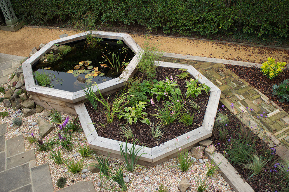 This is an example of a large modern back formal partial sun raised pond for summer in Other with a water feature and gravel.
