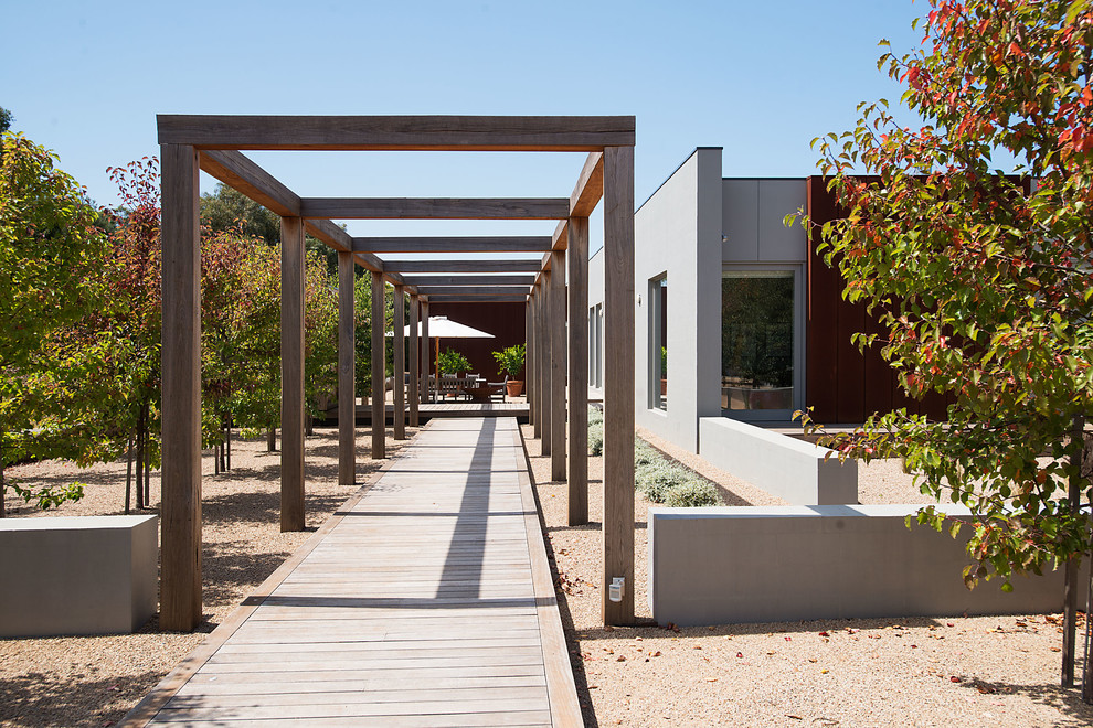 Cette photo montre un jardin avec pergola tendance avec une exposition partiellement ombragée et une terrasse en bois.