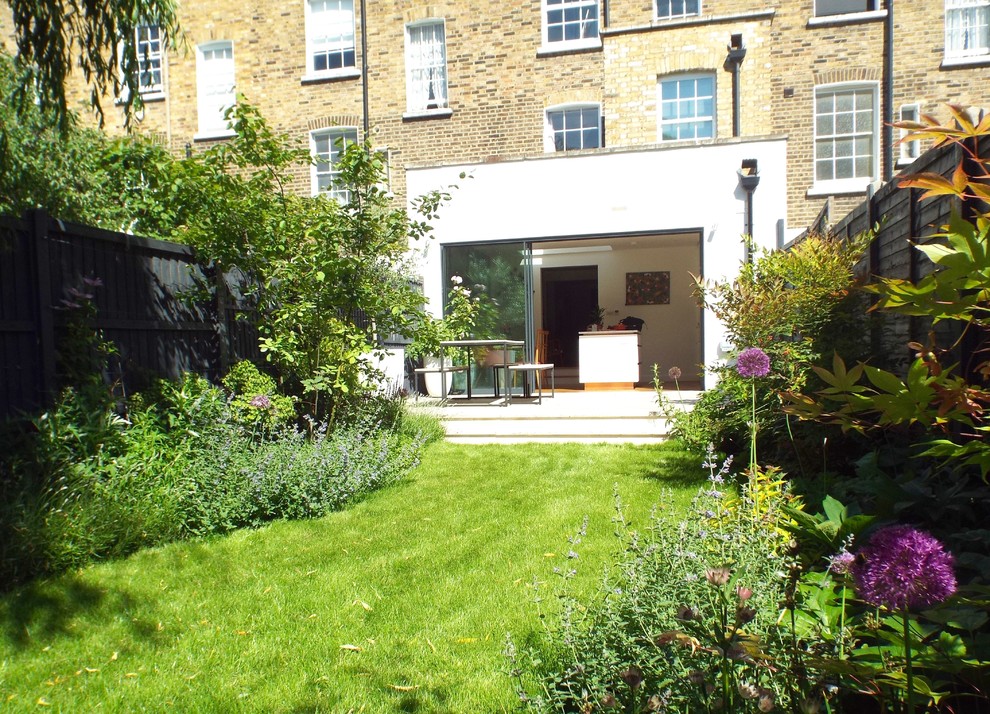 На фото: участок и сад среднего размера на заднем дворе в современном стиле с покрытием из каменной брусчатки с