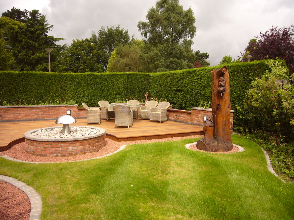 Diseño de jardín clásico renovado de tamaño medio en patio trasero con jardín francés y entablado