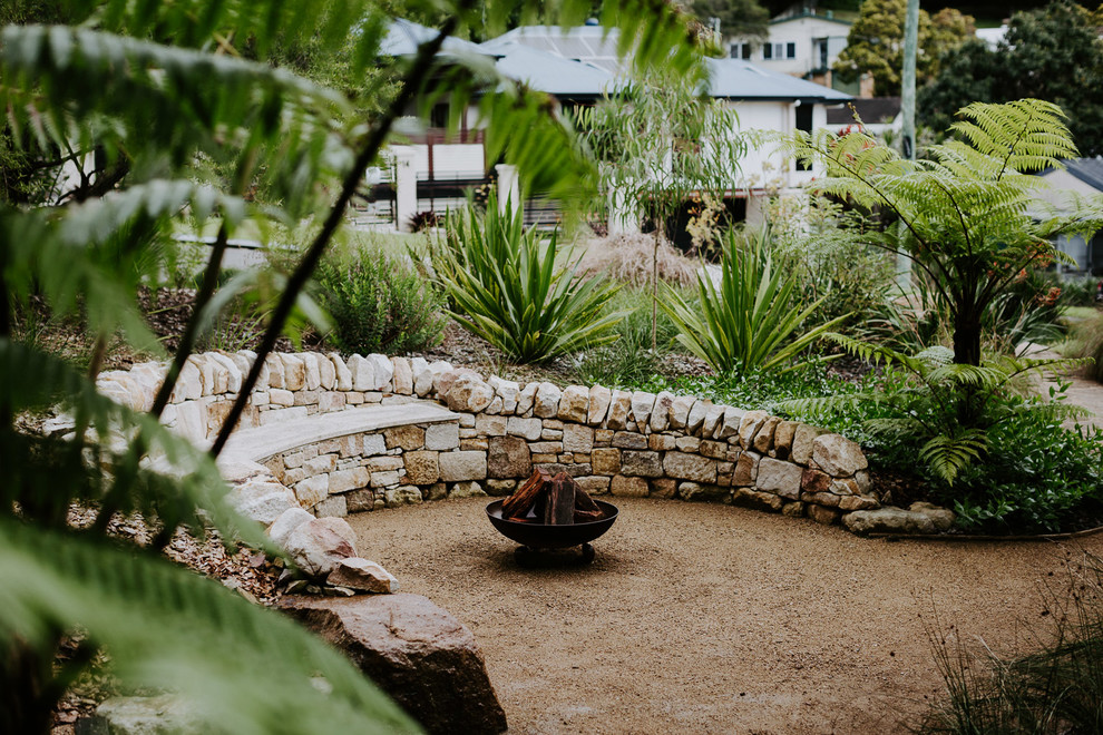 Photo of a medium sized contemporary front xeriscape full sun garden in Sunshine Coast with a rockery and gravel.