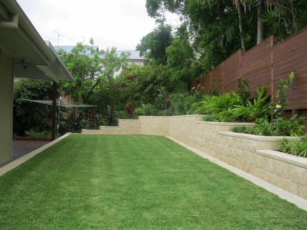 Design ideas for a modern back garden in Sunshine Coast with a retaining wall.