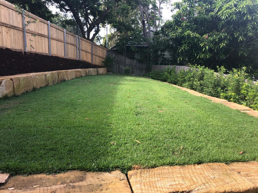 Mittelgroßer Klassischer Garten im Winter, hinter dem Haus mit Sportplatz, Spielgerät, direkter Sonneneinstrahlung und Mulch in Brisbane