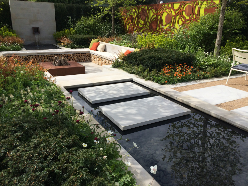 Foto de jardín contemporáneo de tamaño medio con jardín francés y cascada