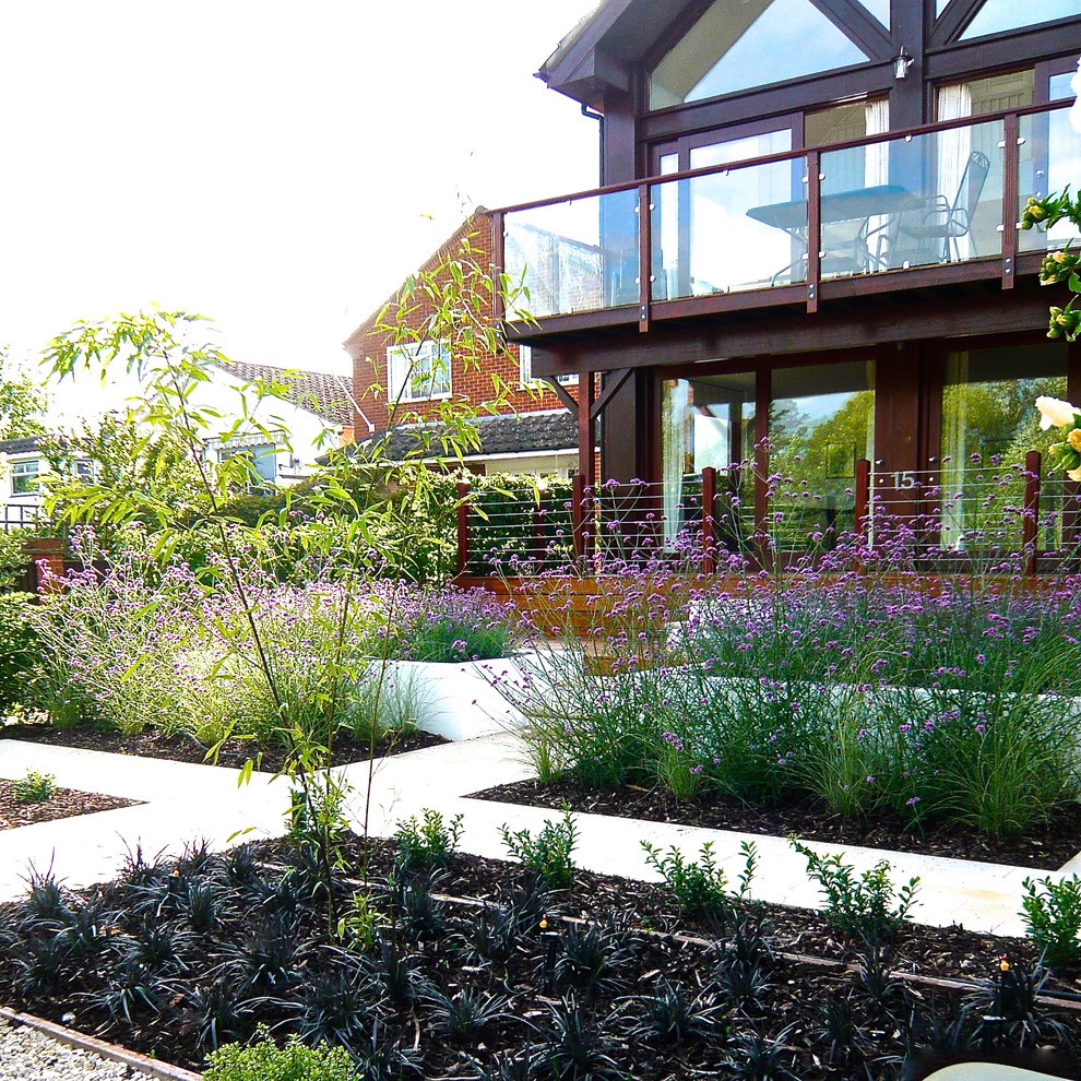 Пример оригинального дизайна: маленький солнечный, летний регулярный сад на переднем дворе в современном стиле с хорошей освещенностью, высокими грядками и покрытием из гравия для на участке и в саду