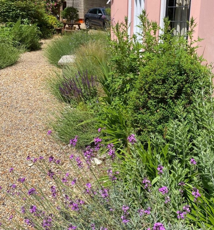 Imagen de jardín de secano de estilo de casa de campo grande en patio delantero con parterre de flores, exposición total al sol y gravilla