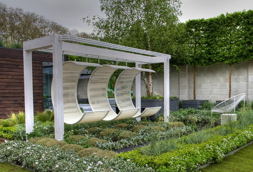 Cette photo montre un jardin moderne de taille moyenne avec une exposition ensoleillée et une terrasse en bois.