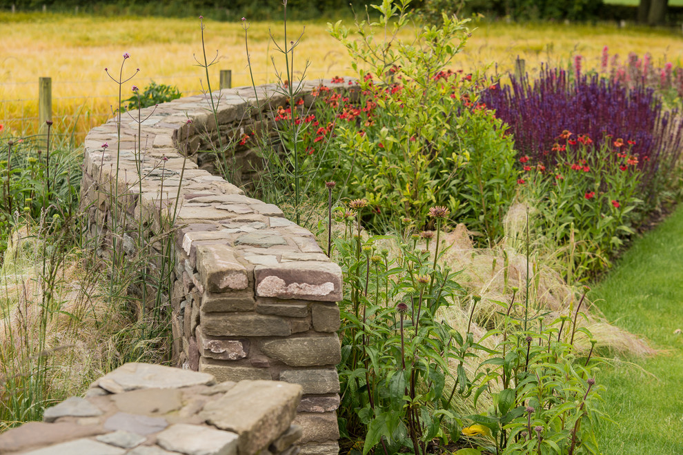 Esempio di un grande giardino country esposto in pieno sole dietro casa in estate con fontane e pavimentazioni in pietra naturale