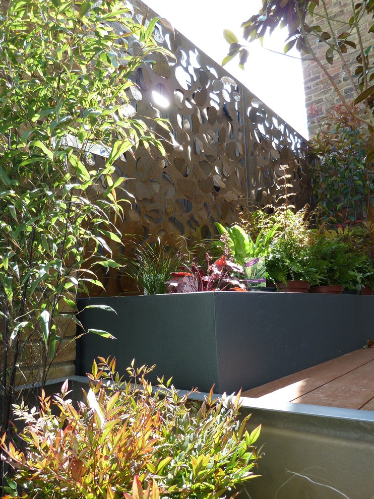 This is an example of a small modern front partial sun garden in London.
