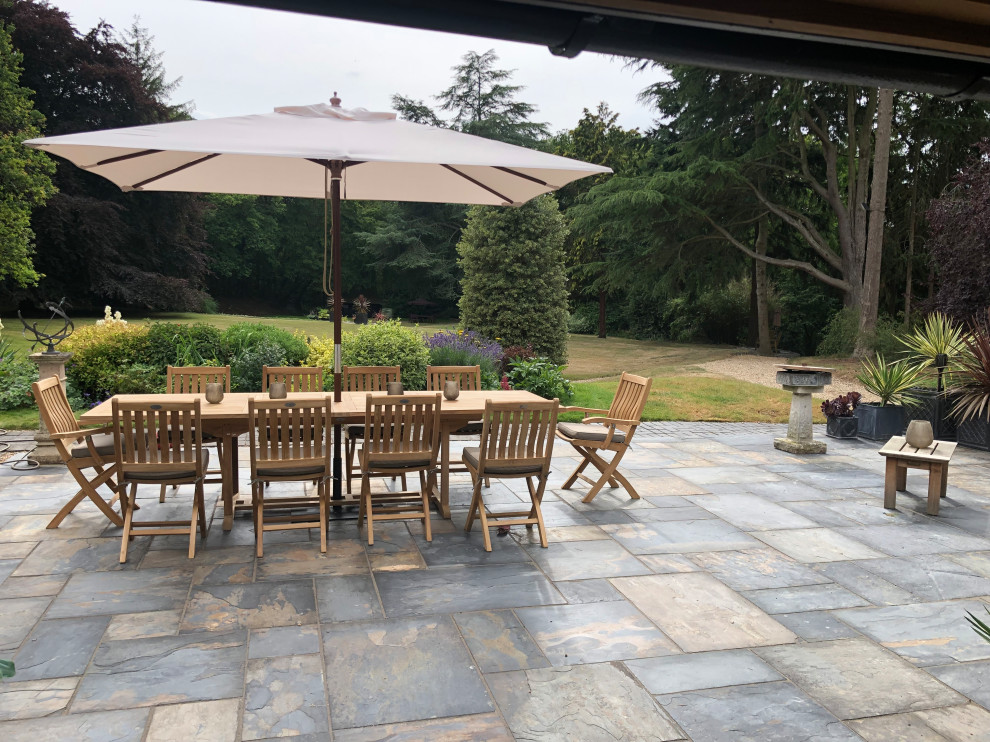 Large farmhouse patio in Other with natural stone paving.