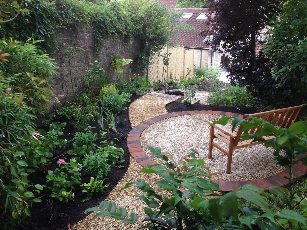 This is an example of a medium sized rustic back garden in Other with a retaining wall and gravel.