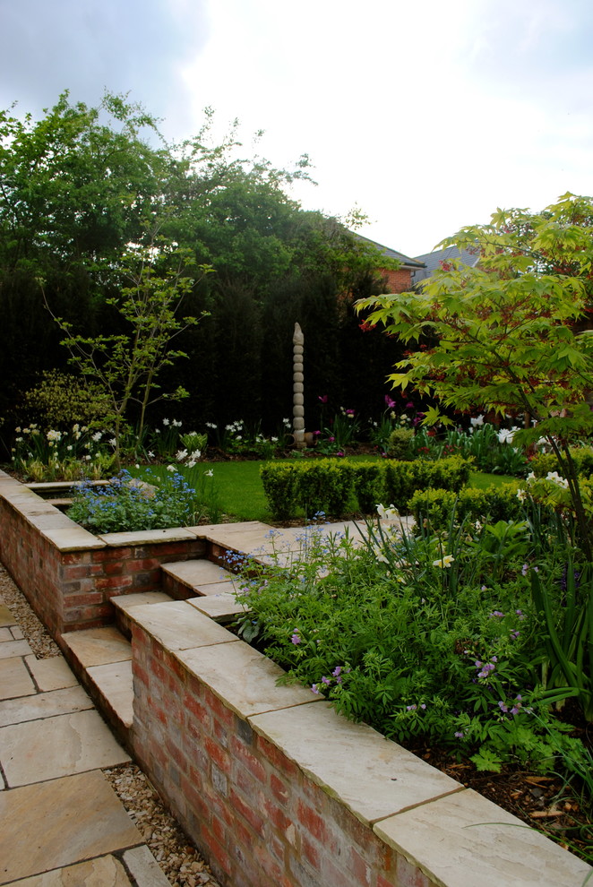 Свежая идея для дизайна: весенний участок и сад среднего размера на заднем дворе в классическом стиле с подпорной стенкой и полуденной тенью - отличное фото интерьера