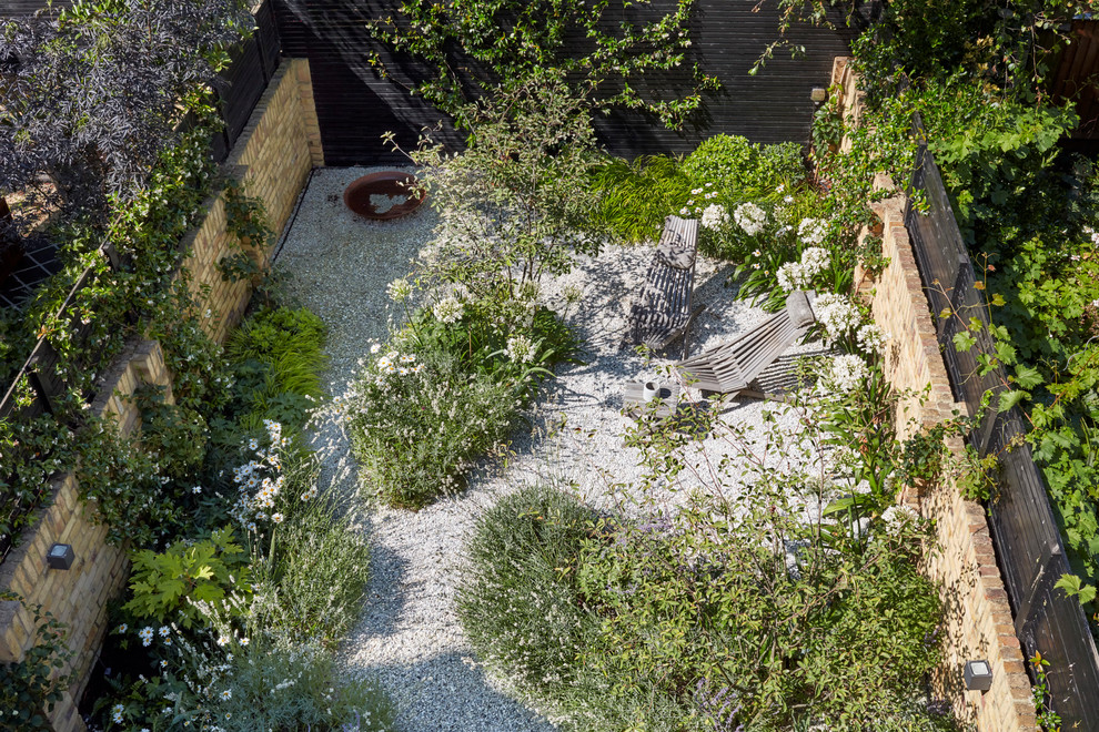 Diseño de camino de jardín mediterráneo de tamaño medio en primavera en patio trasero con exposición parcial al sol y gravilla