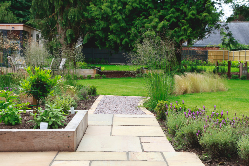 На фото: регулярный сад среднего размера на заднем дворе в современном стиле с покрытием из каменной брусчатки с