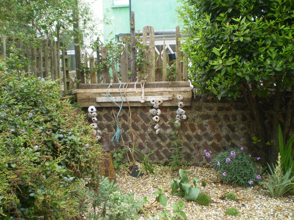 This is an example of a medium sized nautical courtyard xeriscape partial sun garden in Sussex with gravel.