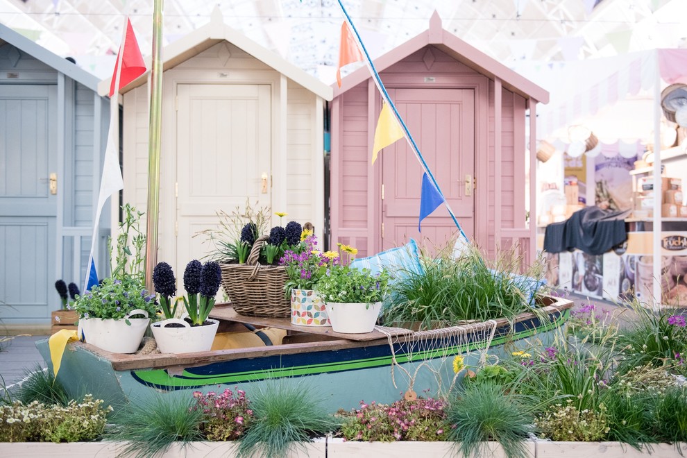 Réalisation d'un petit jardin arrière marin l'été avec une exposition ensoleillée et une terrasse en bois.
