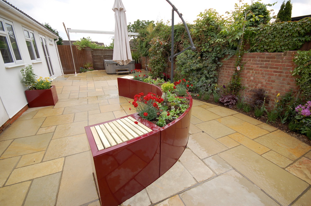 Small contemporary back garden in Essex with natural stone paving.