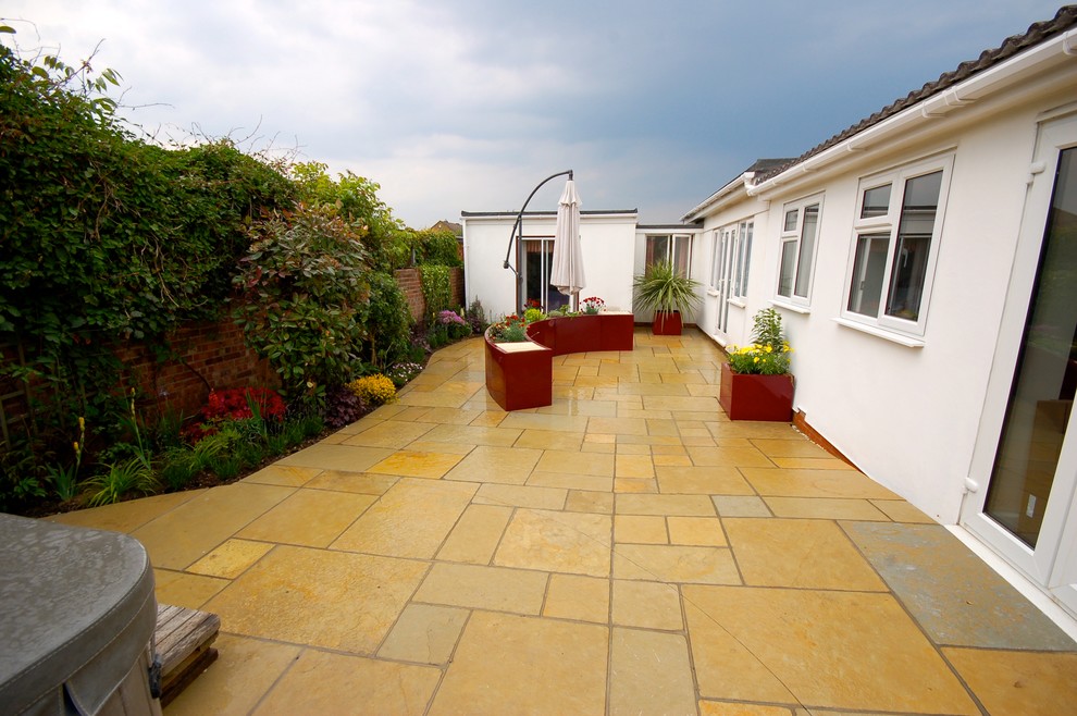 Inspiration for a small contemporary back garden in Essex with natural stone paving.