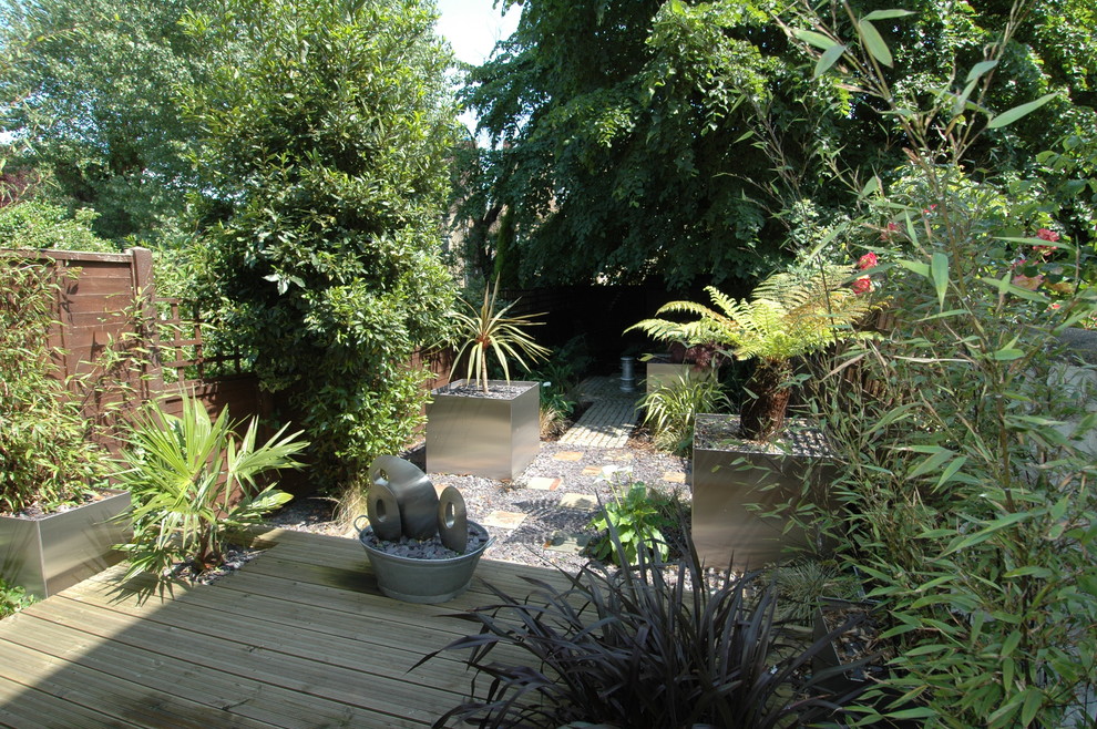 Exemple d'un petit jardin arrière chic avec une exposition ombragée et des pavés en béton.