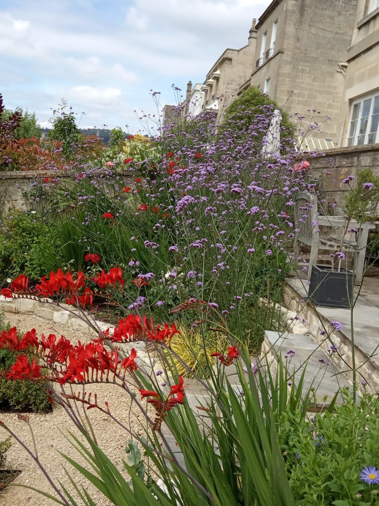 Idées déco pour un jardin à la française arrière éclectique de taille moyenne et l'été avec une exposition ensoleillée et des pavés en pierre naturelle.