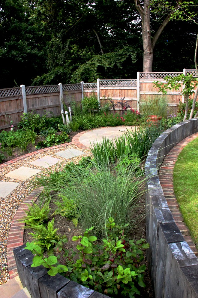 This is an example of a mid-sized partial sun hillside retaining wall landscape in London.