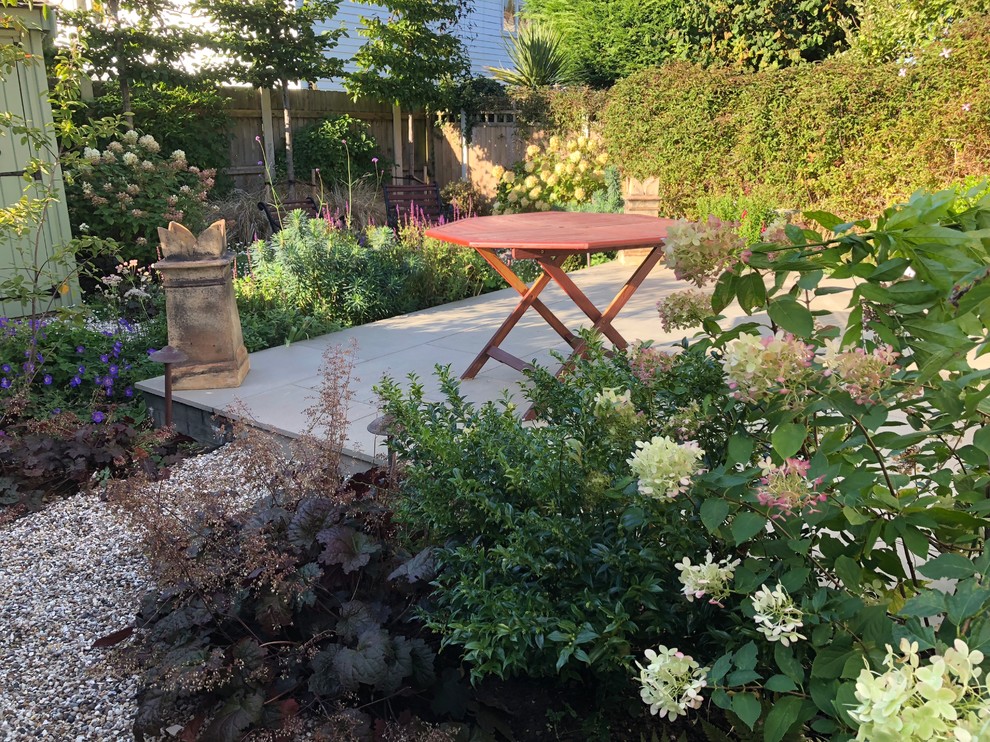 Kleiner, Halbschattiger Klassischer Garten hinter dem Haus mit Natursteinplatten