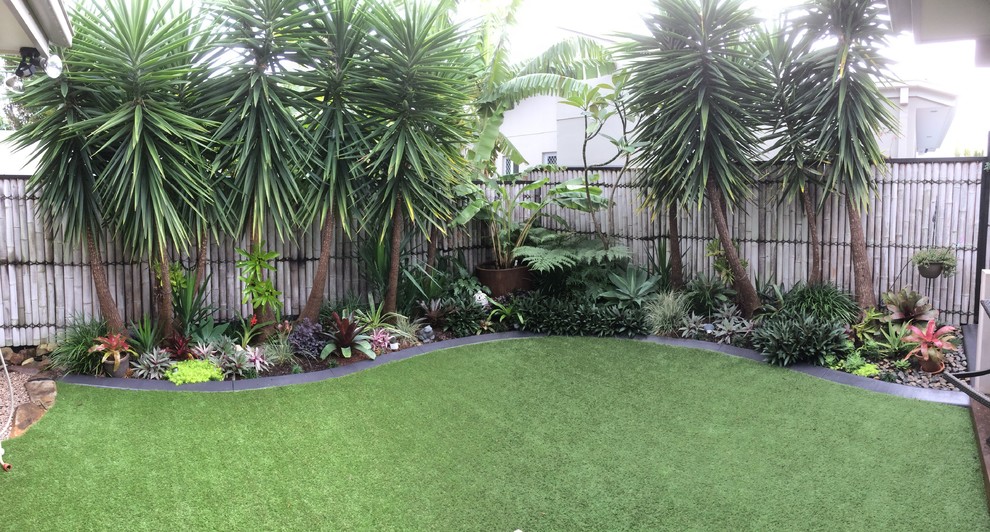 На фото: летний регулярный сад среднего размера на заднем дворе в морском стиле с растениями в контейнерах и полуденной тенью с