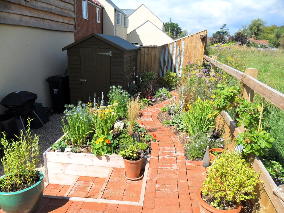 Kleiner, Schattiger Eklektischer Garten im Sommer, neben dem Haus mit Pflastersteinen in Sonstige