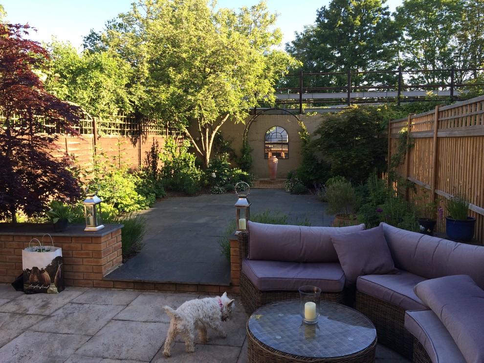 Geometrischer, Kleiner Moderner Garten im Sommer, hinter dem Haus mit Natursteinplatten in Wiltshire