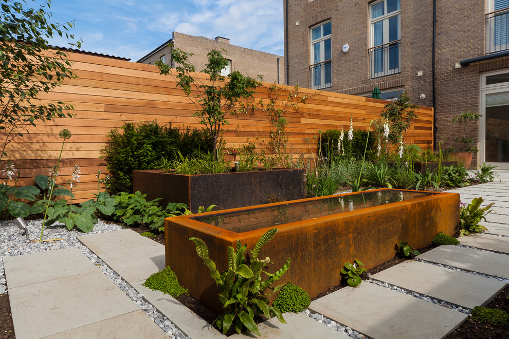Идея дизайна: солнечный участок и сад среднего размера на заднем дворе в современном стиле с хорошей освещенностью и мощением тротуарной плиткой