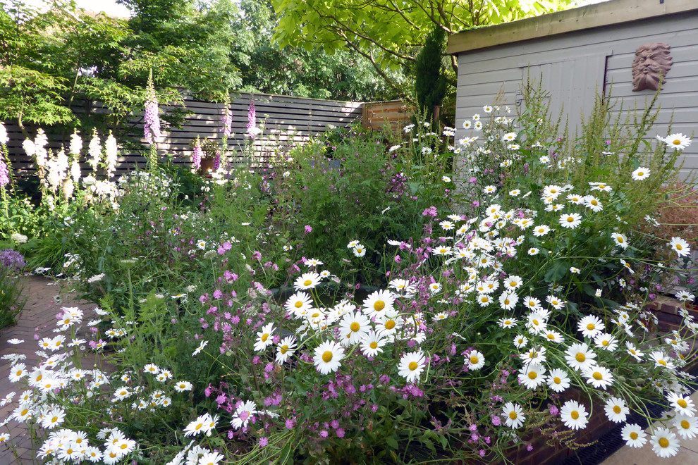 Exempel på en liten klassisk gårdsplan i full sol som tål torka på sommaren, med en trädgårdsgång och marksten i tegel