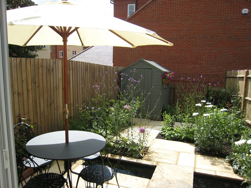 Diseño de jardín bohemio pequeño en patio trasero con exposición parcial al sol y adoquines de piedra natural