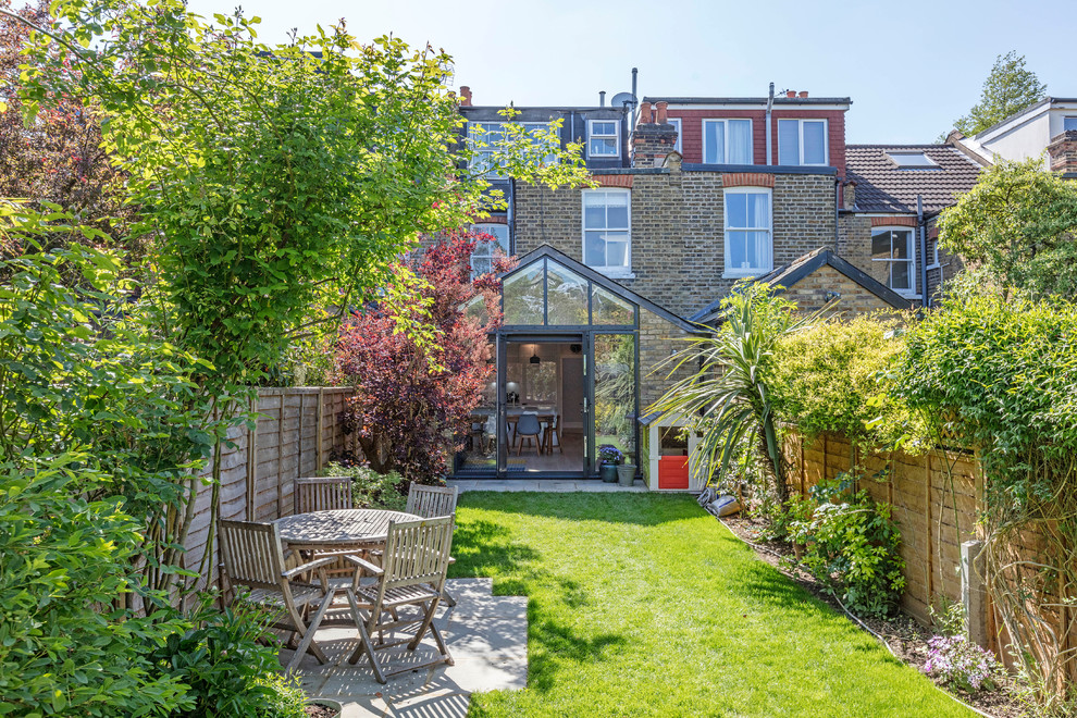 Photo of a mid-sized traditional backyard landscaping in London.