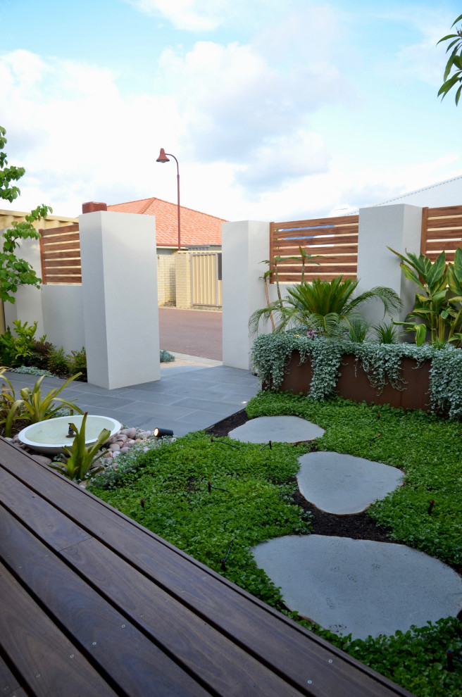 Aménagement d'un petit jardin avant contemporain au printemps avec une exposition ensoleillée et des pavés en pierre naturelle.