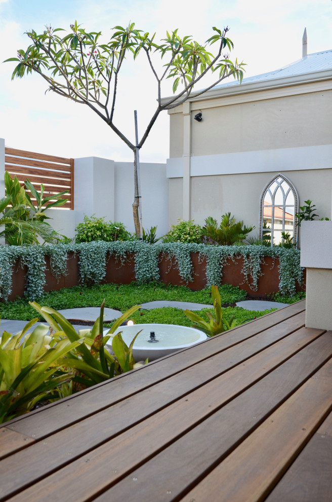 Exemple d'un petit jardin avant tendance au printemps avec une exposition ensoleillée et une terrasse en bois.