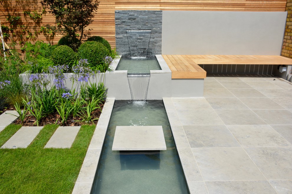 Esempio di un laghetto da giardino contemporaneo esposto in pieno sole di medie dimensioni e dietro casa in estate con pavimentazioni in pietra naturale