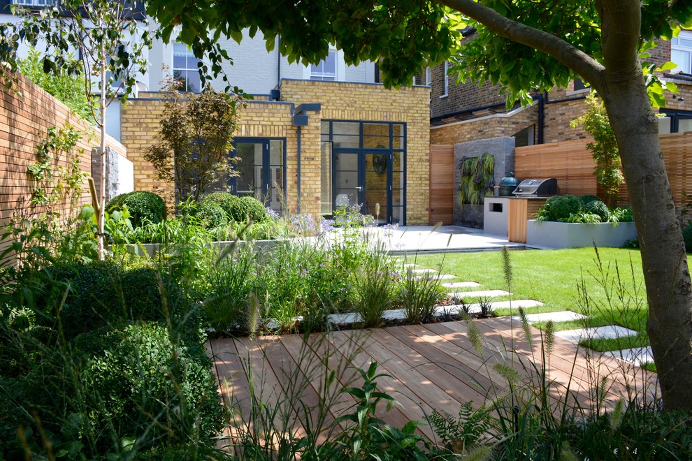 Mittelgroßer Moderner Gartenteich im Sommer, hinter dem Haus mit direkter Sonneneinstrahlung und Natursteinplatten in London