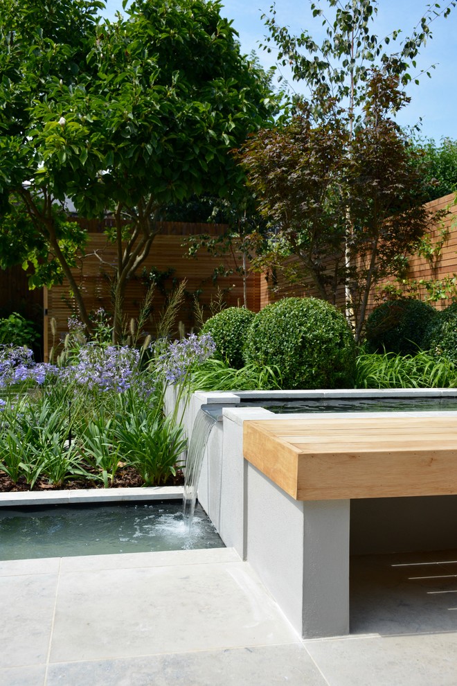 Mittelgroßer Moderner Garten im Sommer, hinter dem Haus mit direkter Sonneneinstrahlung und Natursteinplatten in London